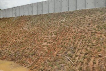 A slope reinforced with concrete barriers and structures to prevent erosion and provide long-term stability.